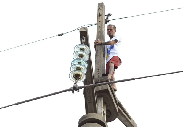 Bombeiros tentam resgatar homem que subiu em poste